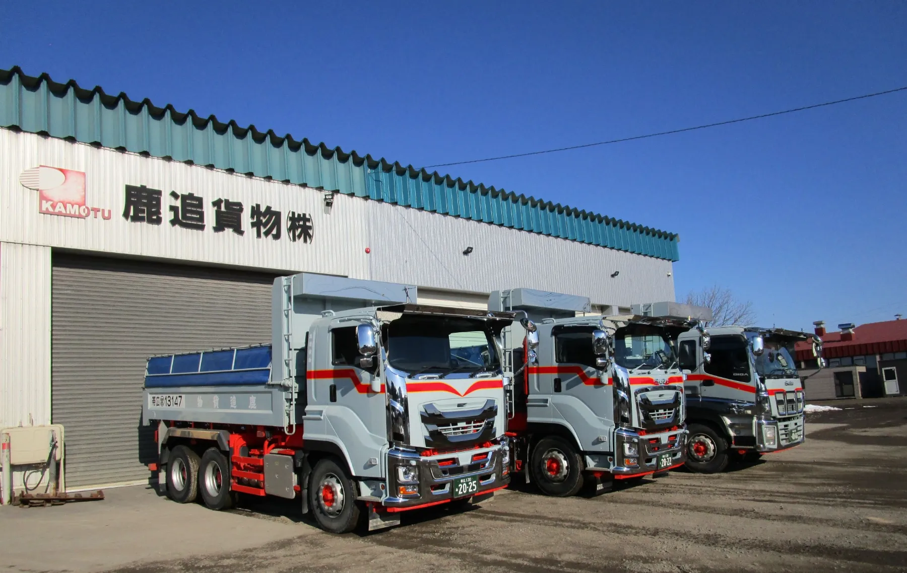 鹿追貨物自動車の社屋前に並ぶ大型ダンプ